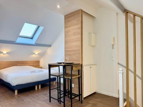 a small bedroom with a bed and a small table at Wellness Suite Ponsardin 3 - Reims Centre in Reims