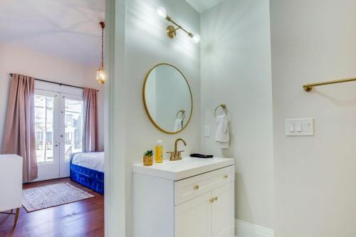 a white bathroom with a sink and a mirror at 6br New Orleans Speakeasy Hot Tub & Playground in Louisville