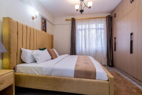 a bedroom with a large bed and a window at Luxurious Nairobi Apartment with City and Garden Views in Nairobi
