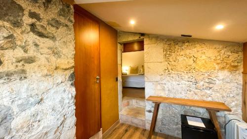 a room with a stone wall and a hallway at Hotel Molí de l'Escala in L'Escala
