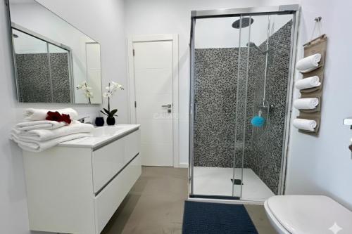 a white bathroom with a shower and a sink at Ecoloft Aldea in San Miguel de Abona