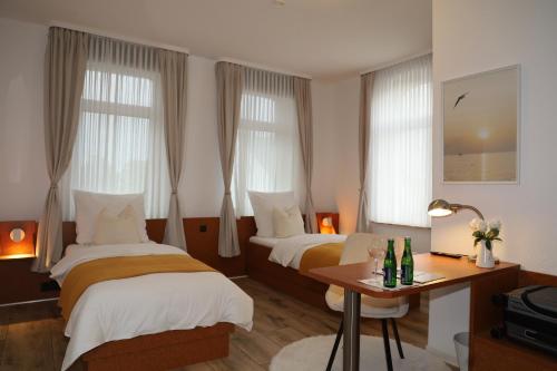 um quarto de hotel com duas camas e uma mesa em Hotel Mutter Buermann em Hemmingen