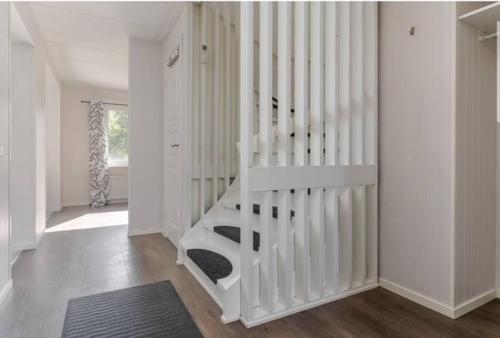 a white staircase in a white room with a rug at Day To Day Motel in Ludvika