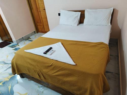 a hotel room with a bed with a book on it at Radhika Residency in Perintalmanna