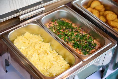 Apricot Hotel Yerevan في يريفان: صينيتان من الطعام في مطبخ مع البطاطس