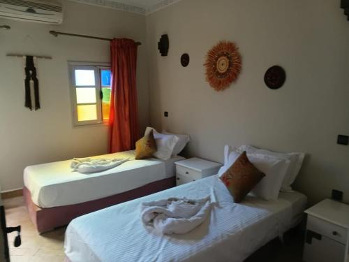a bedroom with two beds and a window at Riad Le Bijou de Zahra Marrakech Kasbah in Marrakech