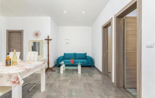 uma sala de estar com um sofá azul e uma mesa em Apartman Topolino em Vodnjan