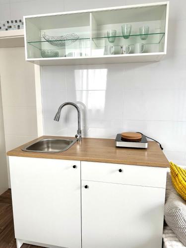 a kitchen with white cabinets and a sink at Miniapartment mit Bad und Kochnische in Dingolfing