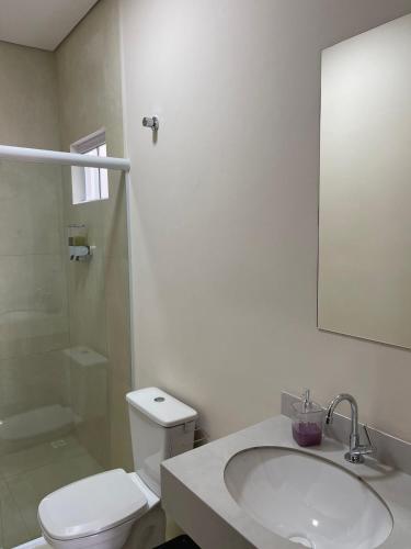 a bathroom with a toilet and a sink and a shower at Apartamento em Sinop 11 in Sinop