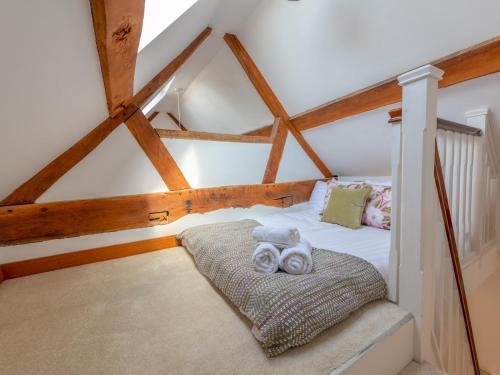 a bedroom with a bed with two towels on it at Pass the Keys Charming Granary Escape Garden Countryside in Much Wenlock