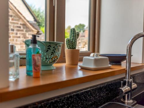 a kitchen counter with a sink and a window at Pass the Keys Charming Granary Escape Garden Countryside in Much Wenlock