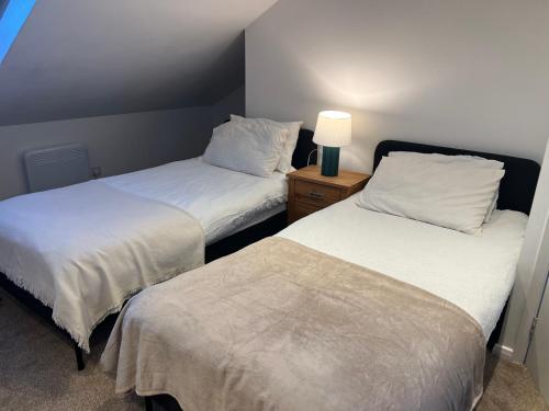 a room with two beds and a lamp on a table at Large triple room in Canada Water London in London