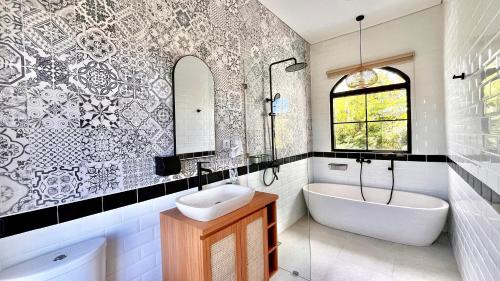 ジンバランにあるThe BALIem Villaの浴槽と洗面台とバスタブを備えたバスルーム