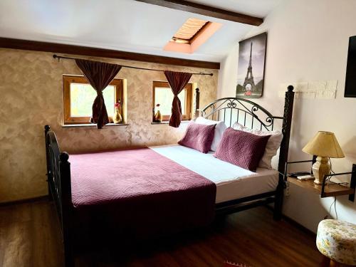 a bedroom with a large bed with a red blanket at Hotel Fjor in Prizren