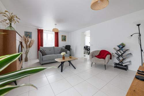 a living room with a couch and a chair and a table at La Rochoise - Parking, Wifi, proche Fontainebleau in La Grande-Paroisse