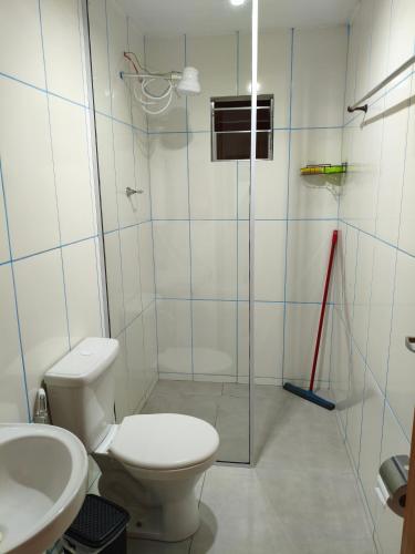 a bathroom with a toilet and a glass shower at Mini lar 2 in Caparaó Velho