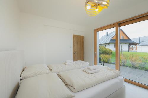 a living room with two white couches and a large window at Môj Hillside in Dolný Kubín
