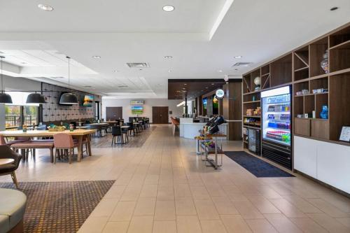 a restaurant with tables and chairs and a large screen at Holiday Inn - Chicago - Tinley Park by IHG in Tinley Park