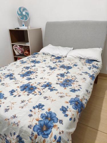 a bed with blue flowers on it in a bedroom at Mini lar 2 in Caparaó Velho