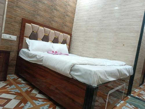 1 cama grande con cabecero de madera en una habitación en Hotel Bhagirath, en Bombay