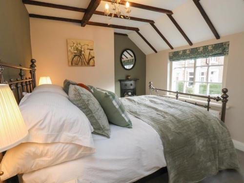 ein Schlafzimmer mit einem Bett mit weißen Laken und Kissen in der Unterkunft Chimes Cottage in Guisborough