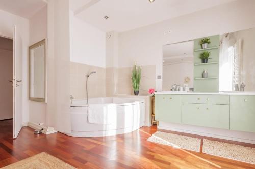 Un baño con bañera, lavabo y espejo. en La Coloc - Chatillon la Palud idéal PROS, en Châtillon-la-Palud