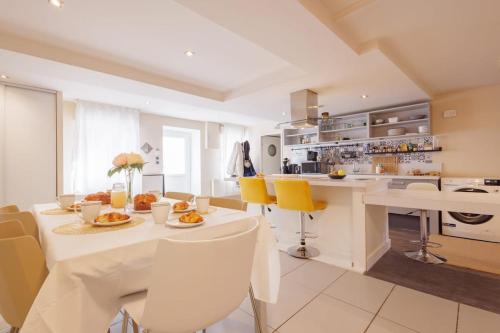 een keuken met een witte tafel en gele stoelen bij La Coloc - Chatillon la Palud idéal PROS in Châtillon-la-Palud