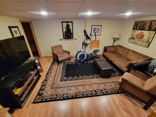 ein Wohnzimmer mit Sofa und Fernseher in der Unterkunft Comfortable Room Rental for a Vacation in Poweshiek County, Iowa in Montezuma