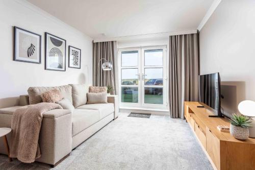a living room with a couch and a television at Old Prestwick Point - Donnini Apartments in Prestwick