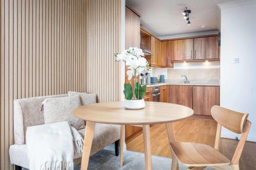 a kitchen with a table with a vase of flowers on it at Old Prestwick Point - Donnini Apartments in Prestwick