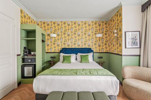 ein Schlafzimmer mit einem großen Bett und einem Stuhl in der Unterkunft Hotel Le Clery in Paris