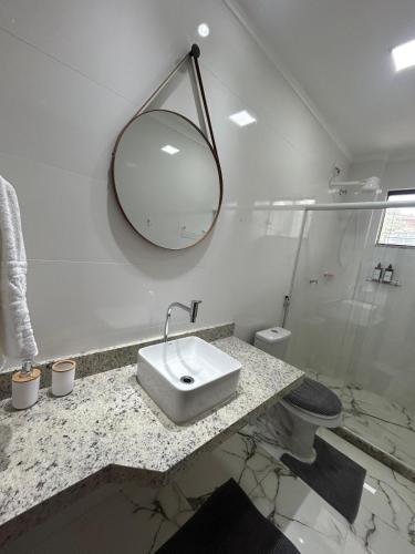 a white bathroom with a sink and a mirror at Apartamento grande em Santa Teresa-ES in Santa Teresa