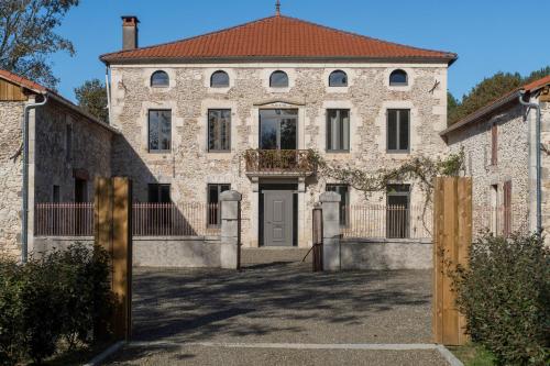 an old stone house with a gate in front of it at DOMAINE De PLAISANCE in Cachen