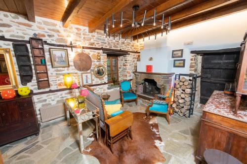sala de estar con muebles y pared de piedra. en Αρχοντικό 1716, en Agios Lavredios