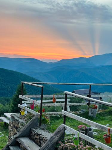 a view of a mountain with a sunset in the background at Pensiunea Casa Ancutei in Ranca