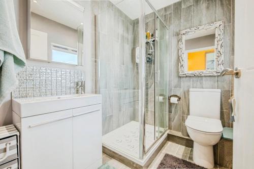 a white bathroom with a shower and a toilet at Beachside in Ferryside