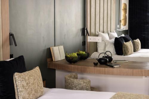 a room with two beds and a table with bowls of fruit at 1.75 Paris La Source in Paris