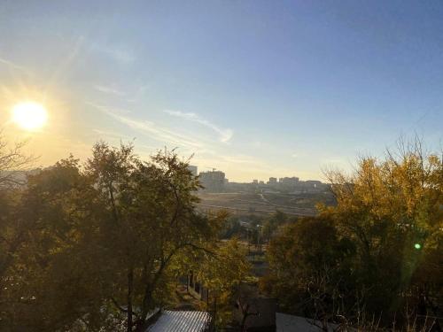 a view of a city with the sun in the sky at Sunrise Apartment Gai Avenue One, Yerevan in Yerevan