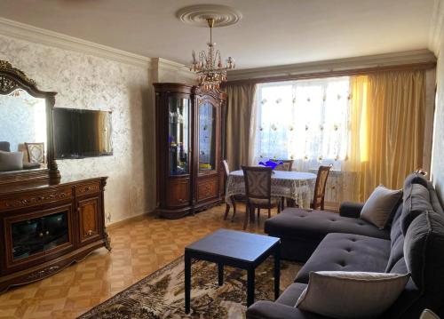 a living room with a couch and a table at Sunrise Apartment Gai Avenue One, Yerevan in Yerevan