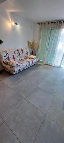 een woonkamer met een bank op een tegelvloer bij La cigala in Le Pradet