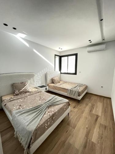 two beds in a room with a staircase at Maison Miralin Beach in Hammam Sousse