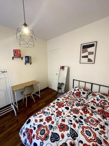 ein Schlafzimmer mit einem Bett, einem Tisch und einem Schreibtisch in der Unterkunft Elegant 2-bedroom apartment near Paris & Château de Vincennes in Nogent-sur-Marne