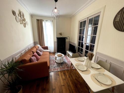 ein Wohnzimmer mit Sofa und Tisch in der Unterkunft Elegant 2-bedroom apartment near Paris & Château de Vincennes in Nogent-sur-Marne