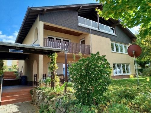 a large house with a porch and a balcony at Haus am Aartalsee in Bischoffen