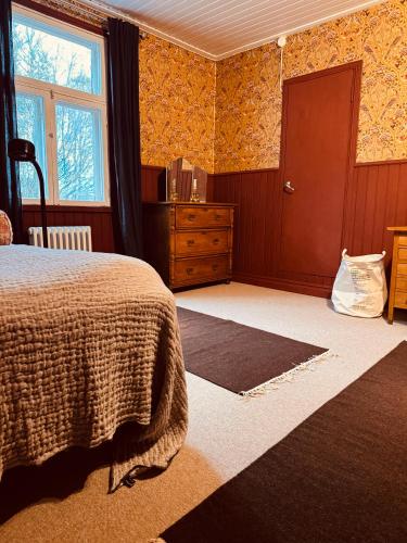 a bedroom with a bed and a dresser and a window at Torp Solbacka in Raseborg