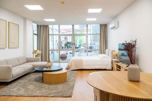 een woonkamer met een bed en een tafel bij Business office - Studio with garage in Linda-a-Velha