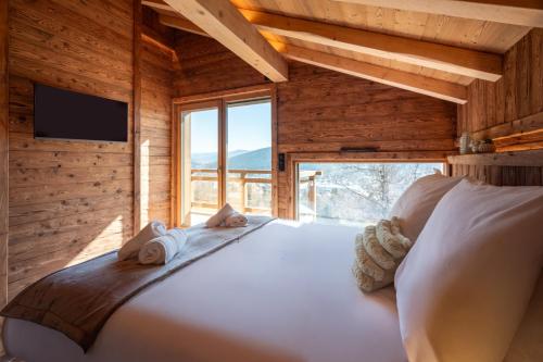 a bedroom with a large bed with a large window at Chalet de Scott, luxe avec spa et sauna in Gérardmer