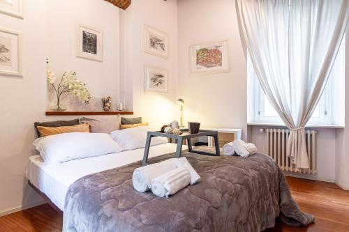 a bedroom with two beds and a table with towels at Suite Manzoni by Houset in Monza