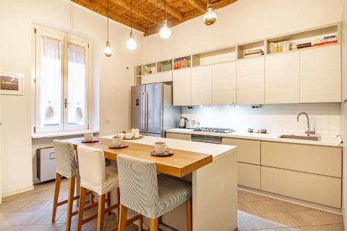 a kitchen with a wooden table and white cabinets at Suite Manzoni by Houset in Monza