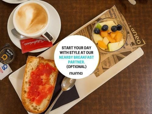 een bord met een stuk pizza en een kop koffie bij Numa Valencia La Xerea in Valencia